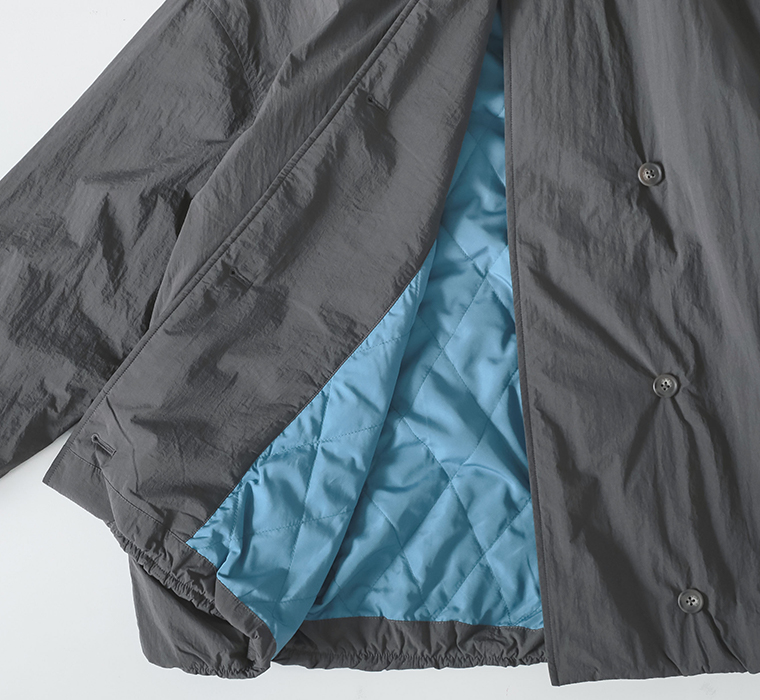 保温中綿「Zermoly」ノーカラーハーフコートの裏地ディテール（ブルーのキルティング裏地）