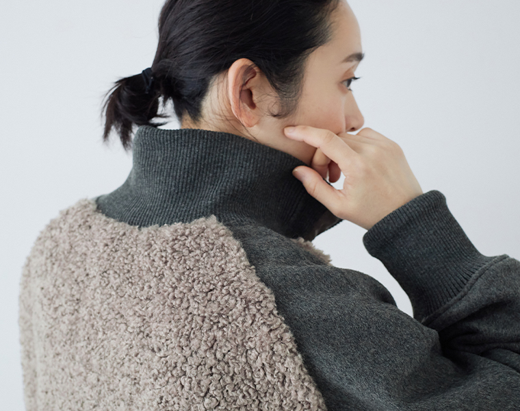 リブ仕様の襟元が見えるボアナイロンハーフコートを後ろからアップにしたカット