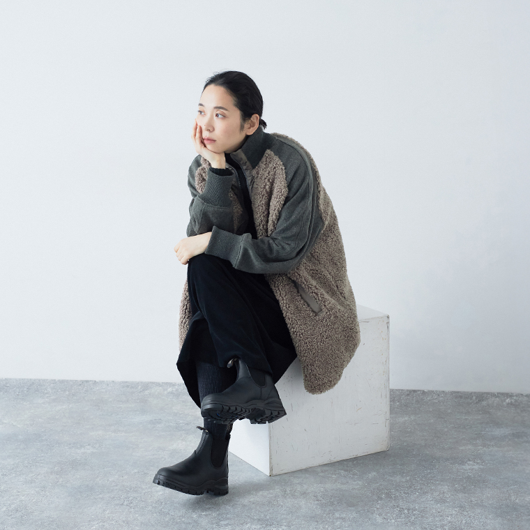 Lilou＆Lilyのボアナイロンハーフコートを着て座った女性