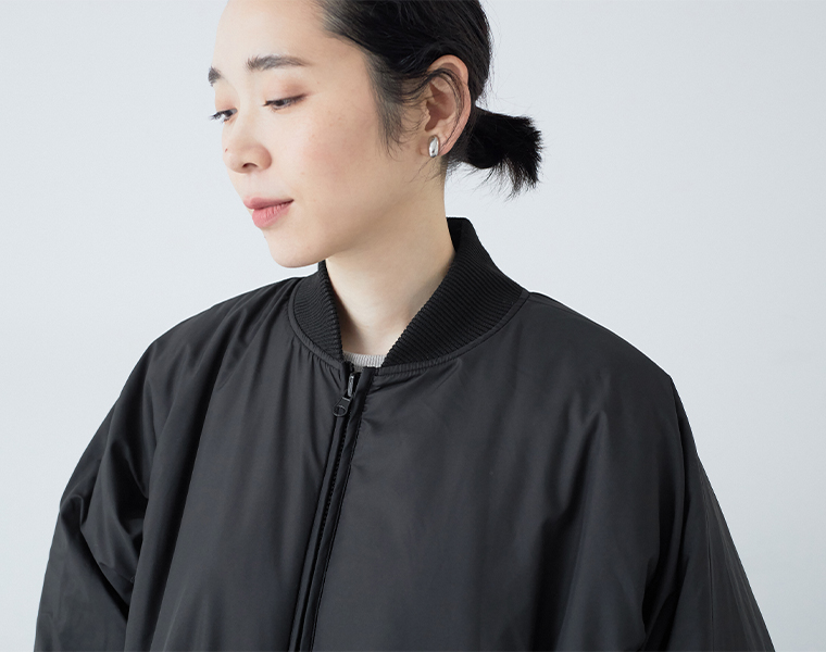 リブ仕様の襟元を見せたリバーシブルコートの着用アップ