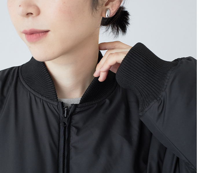 リブ仕様の袖口を見せたリバーシブルコートの着用アップ