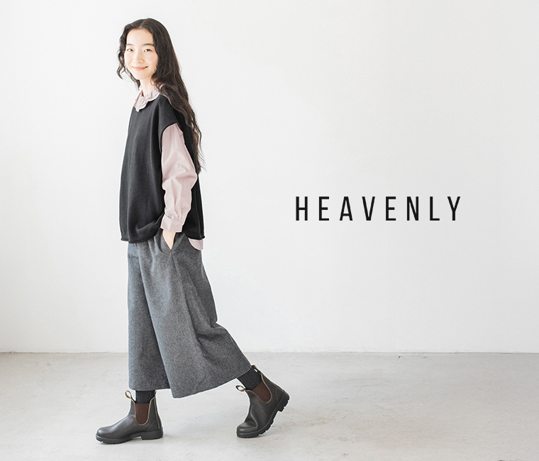 HEAVENLYのウールミックスガウチョパンツ（ダークグレー）と黒のベストを着た女性が横向きで歩いている